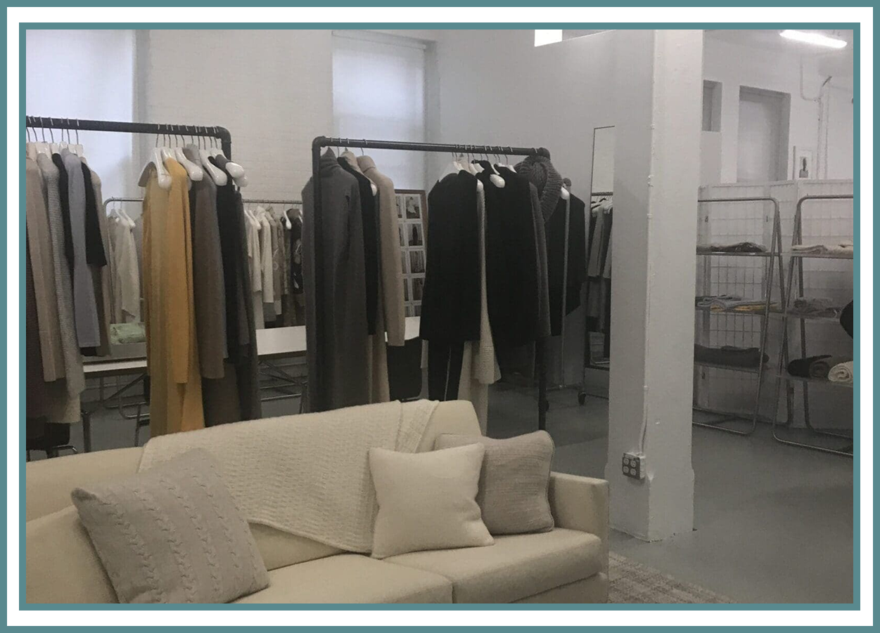 Clothing showroom with racks and sofa.