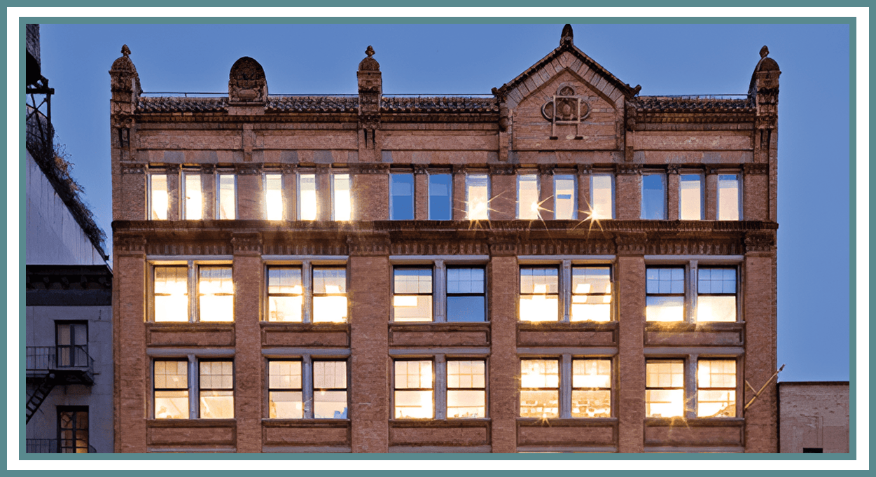 Illuminated brick building exterior at dusk.